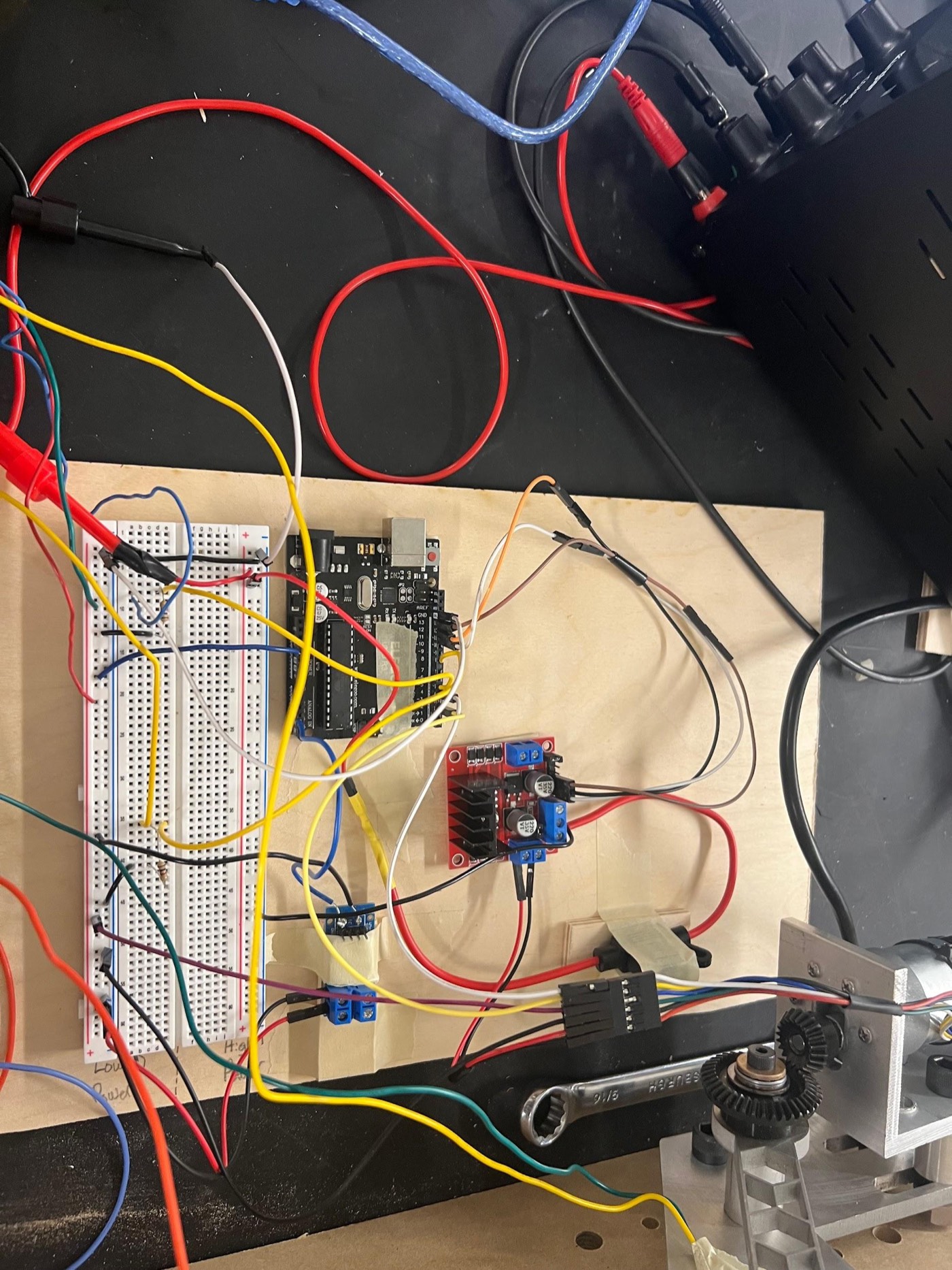 Overhead view of the full electronics stack: Arduino, breadboard, motor driver board, and wiring to the limit switch and motor.